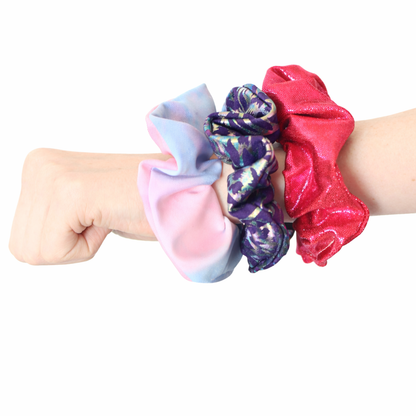 Set of colorful scrunchies on a wrist against a white background