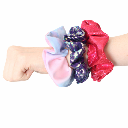 Set of colorful scrunchies on a wrist against a white background